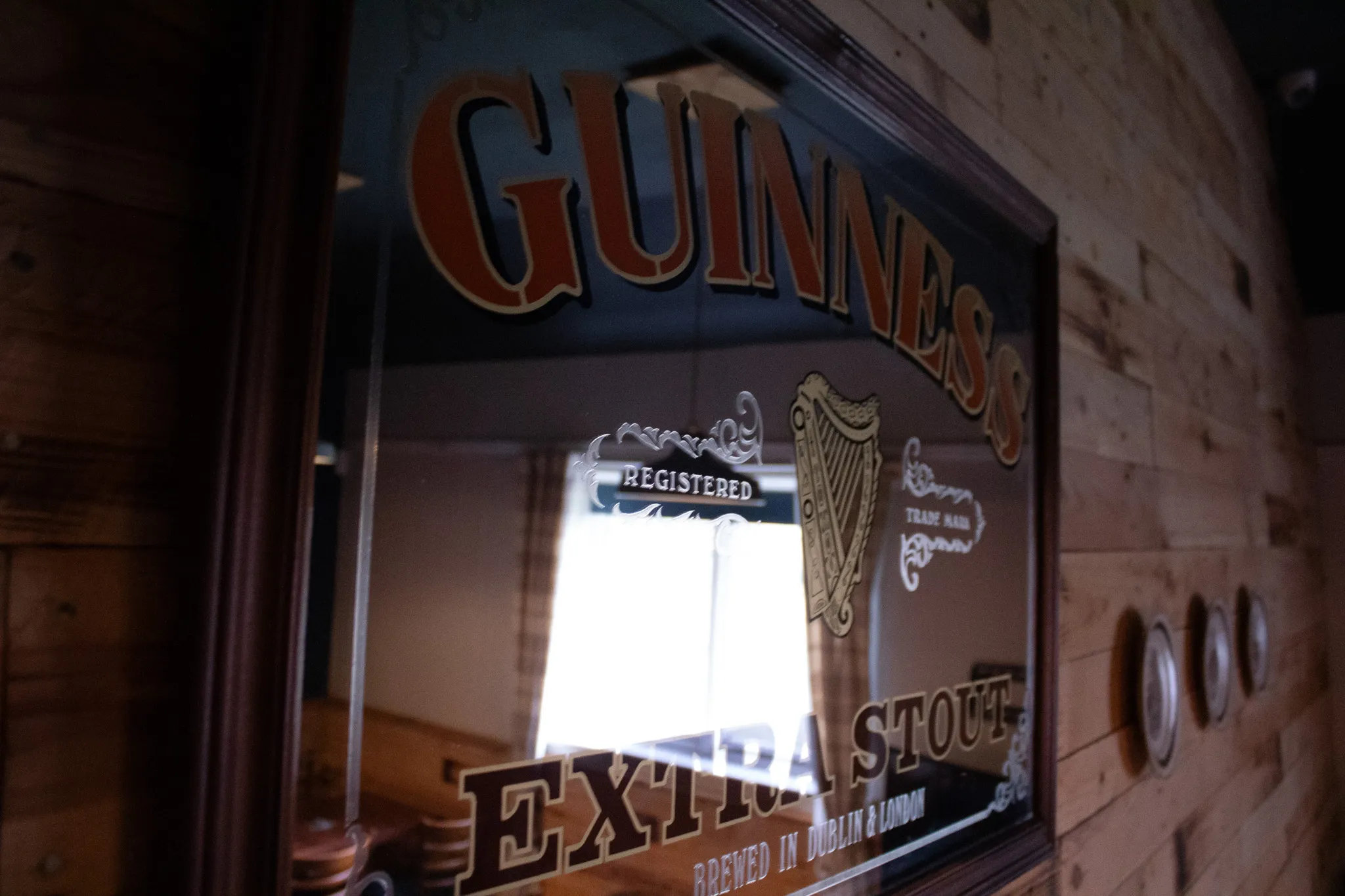 A Guinness mirror and warm timber inside The Crossings Club